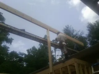 Carpenter setting a ridge beam over a new addition frame — Ice Dam Removal by Roofing Brothers in Frost