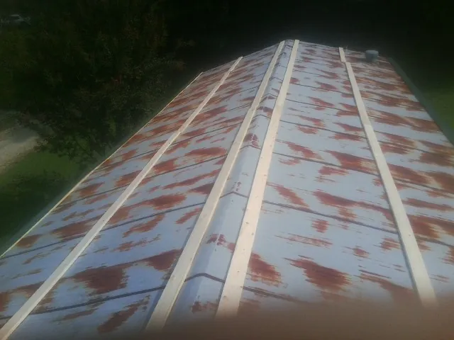 Rusted metal roof panels with new wood purlins before replacement — Storm Damage Roof Repair in Frost by Roofing Brothers