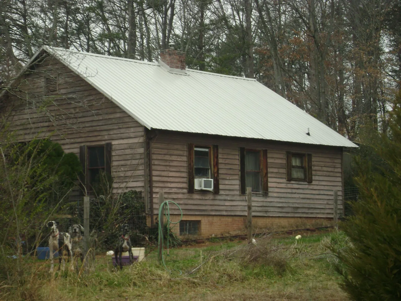 White metal roof on an old wood sided farmhouse, from a Metal Roof Installation job in Frost